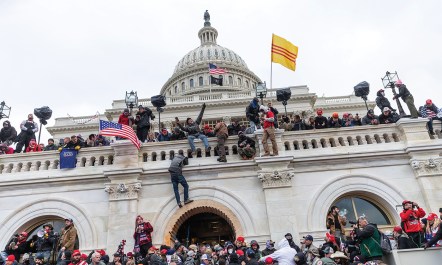 Supporters of former president Donald Trump are pictured scaling the walls of the U.S. Capitol Building on Jan. 6, 2021.