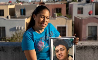 Above her home in Juarez, Nuevo León, Mexico, Elva Rivas holds a portrait of her husband, Roberto Maciel Ramírez, who disappeared in 2010.
