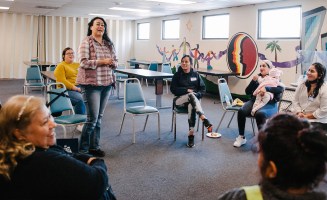 A woman speaking to her peers in a group