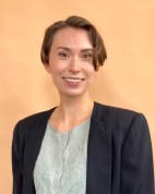 Elena Hodges has short hair and is wearing a gray shirt and black blazer