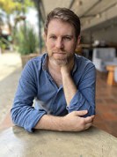 a white man sits at a table