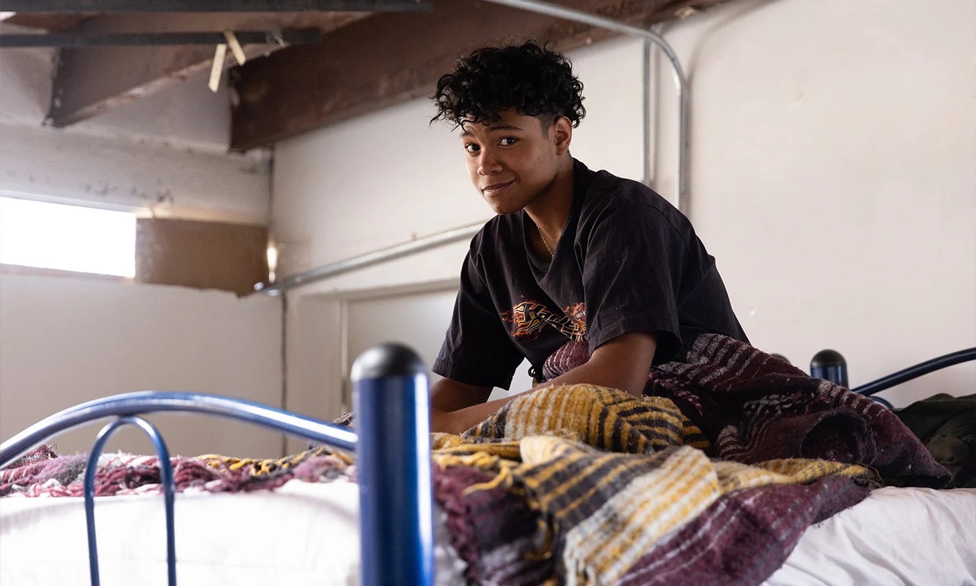 A teenager rests at a migrant shelter in the border city of Ciudad Juarez, just across the Rio Grande River from El Paso, Texas (Feb. 4, 2025). He sits on a bed and looks at the camera.